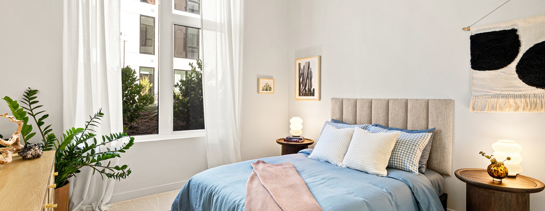 a bedroom with carpet and high ceilings and a large window