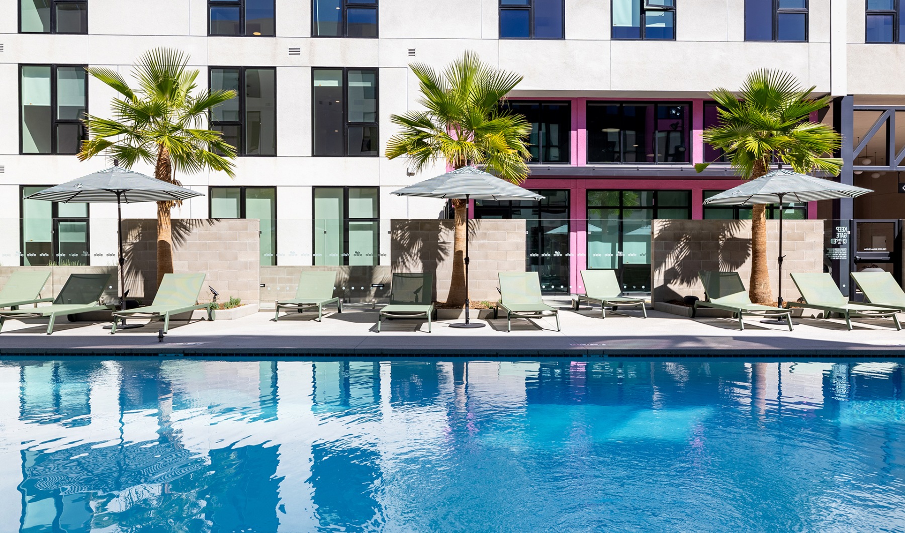 a pool with lounge chairs and umbrellas