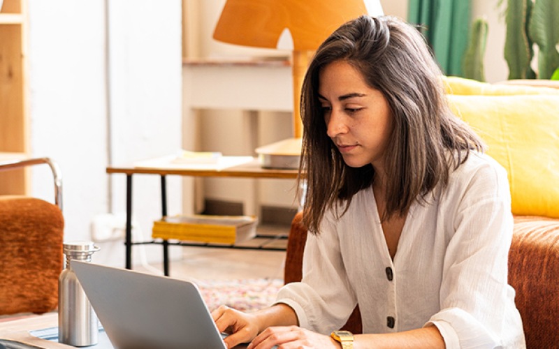 a person typing on a laptop in an apartment