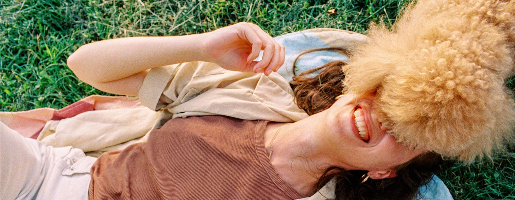 a person laying on the ground playing with a dog